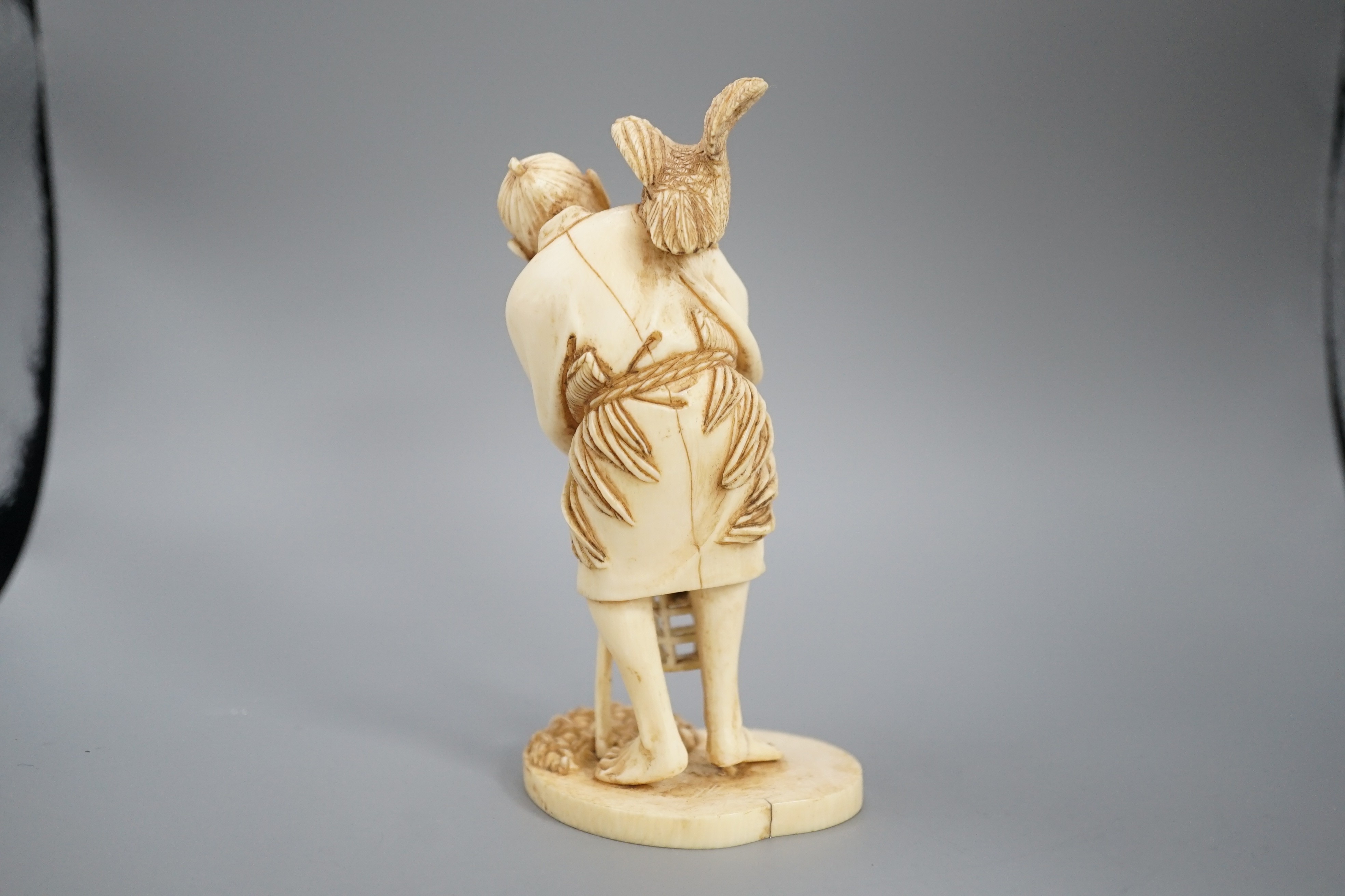 A Japanese ivory okimono of a cormorant fisherman, signed, Meiji period, 11cm and a small carving of a monkey